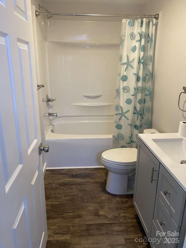 bathroom with wood finished floors, shower / bath combo with shower curtain, toilet, and vanity
