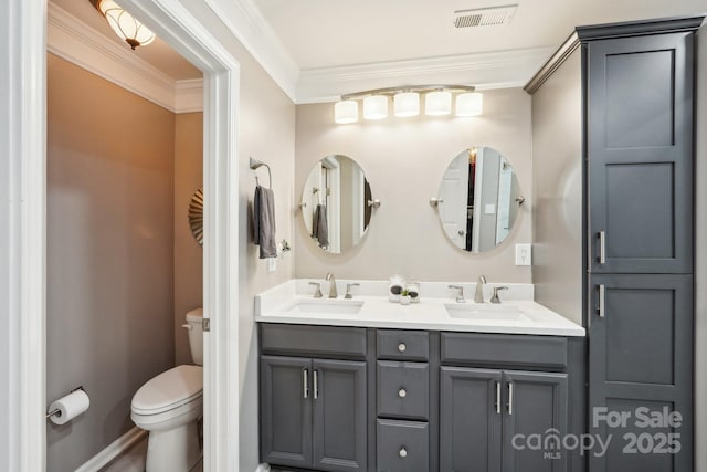 bathroom with visible vents, a sink, ornamental molding, and toilet