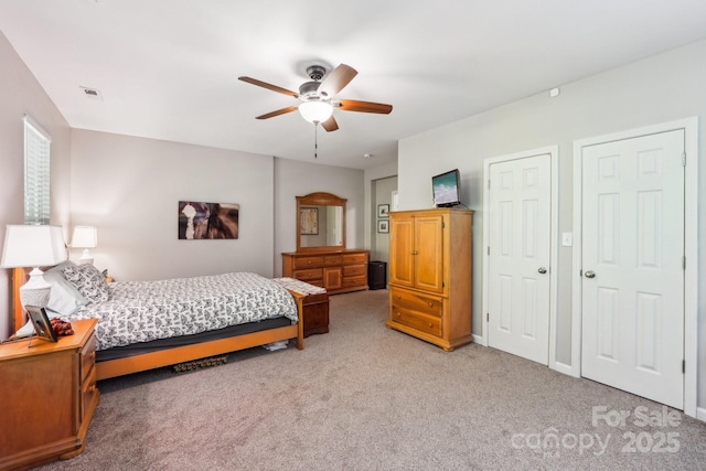 bedroom featuring a ceiling fan, visible vents, and carpet floors