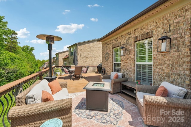 wooden terrace featuring outdoor dining area and an outdoor living space with a fire pit
