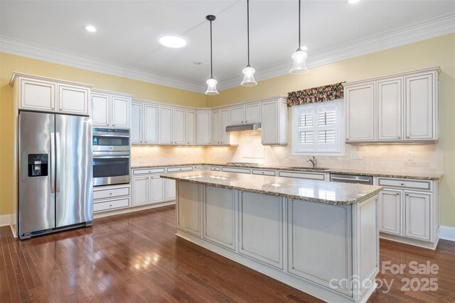 kitchen with decorative backsplash, stainless steel appliances, a sink, and a kitchen island