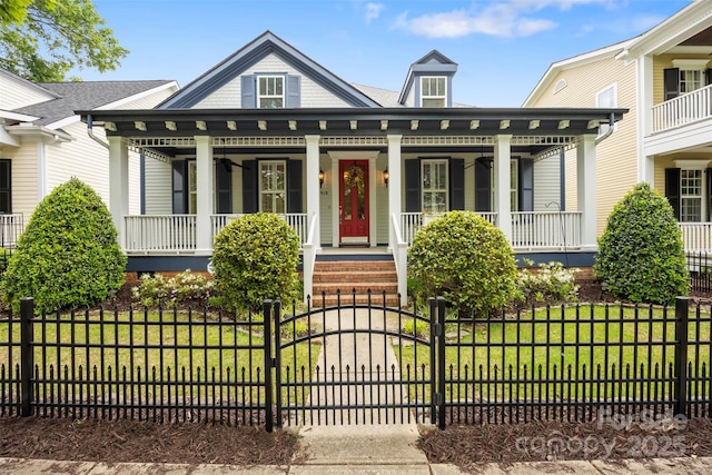 view of front of property featuring a gate, a fenced front yard, a front lawn, and covered porch