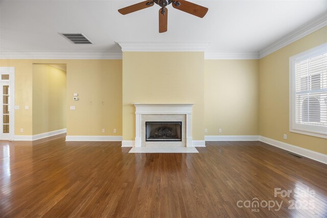 unfurnished living room featuring a high end fireplace, visible vents, crown molding, and a ceiling fan