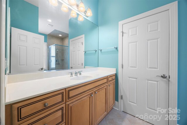 bathroom with a shower stall, tile patterned floors, and vanity