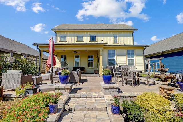 rear view of house with board and batten siding, a patio area, a ceiling fan, and an outdoor living space