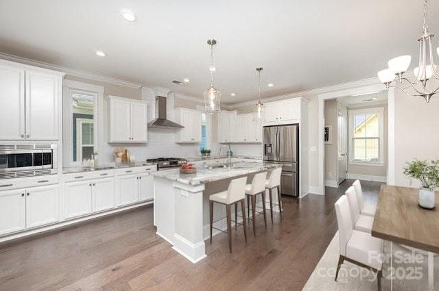 kitchen featuring wall chimney exhaust hood, a sink, stove, crown molding, and stainless steel refrigerator with ice dispenser
