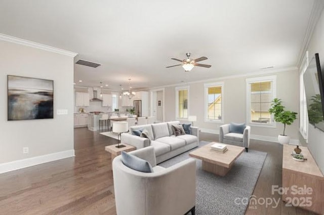 living room featuring wood finished floors, visible vents, a ceiling fan, ornamental molding, and baseboards