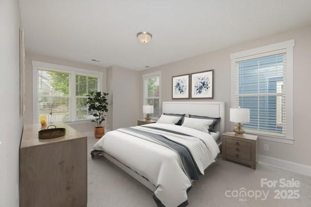bedroom featuring baseboards and multiple windows