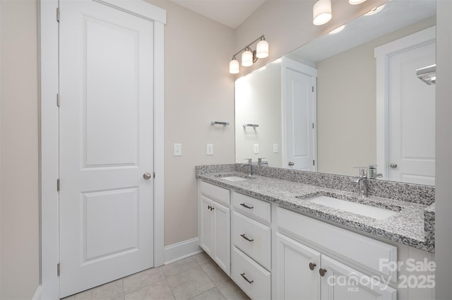 bathroom featuring double vanity, tile patterned flooring, baseboards, and a sink