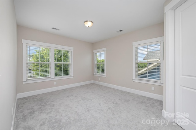 carpeted empty room with baseboards and visible vents