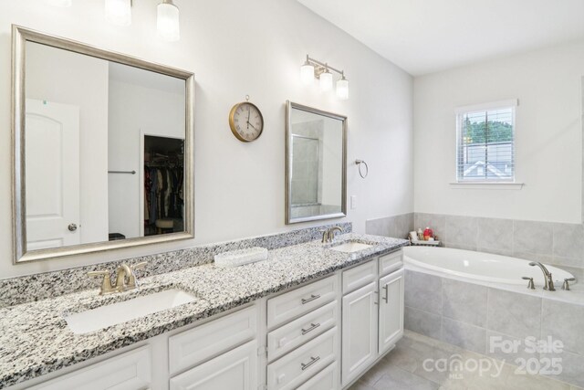 15108 Autumn Sage Dr, Charlotte, NC 28278 - bathroom featuring double vanity, a garden tub, tile patterned flooring, a shower, and a spacious closet