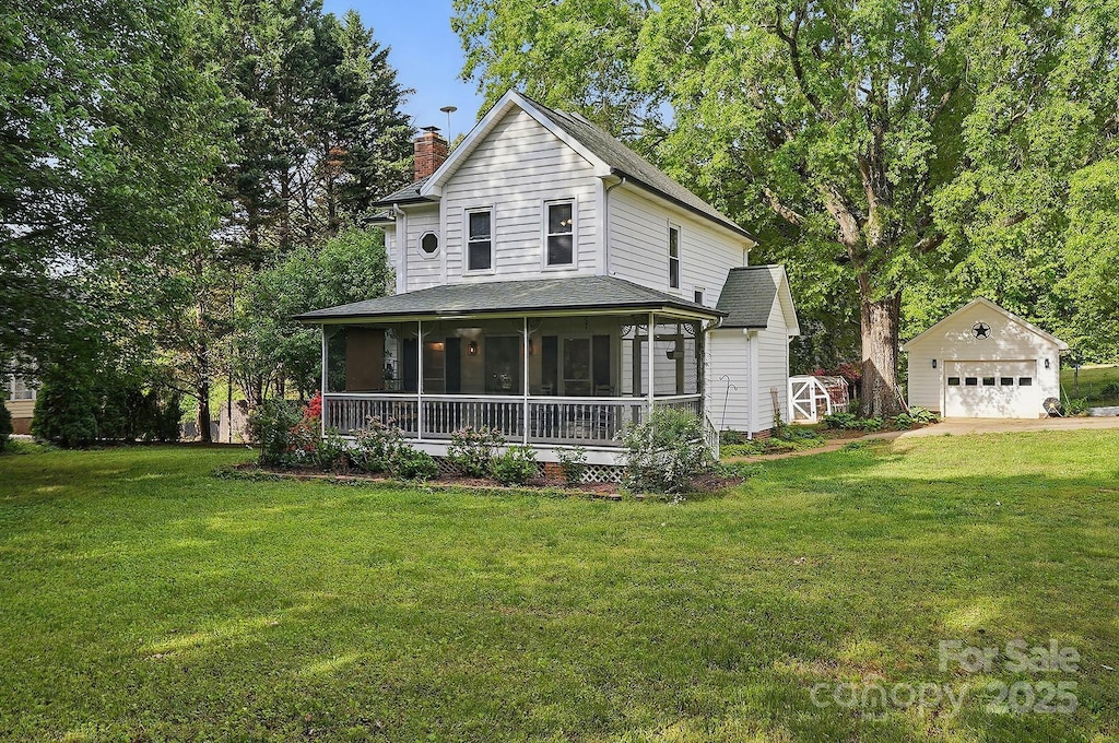 farmhouse with a front yard, a sunroom, an outdoor structure, a detached garage, and a chimney