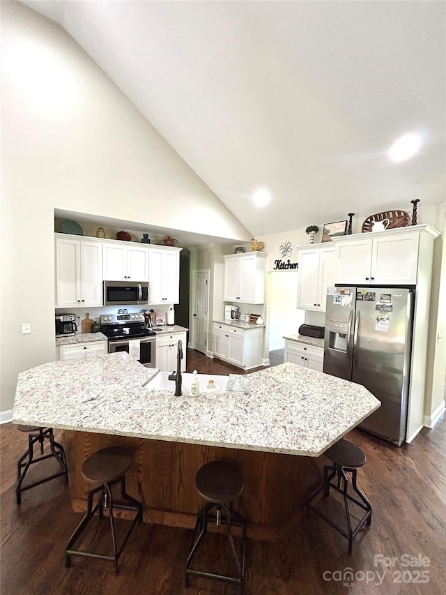 5817 Wingate Hill Rd, Denver, NC 28037 - kitchen with appliances with stainless steel finishes, a spacious island, white cabinetry, a breakfast bar area, and dark wood-type flooring