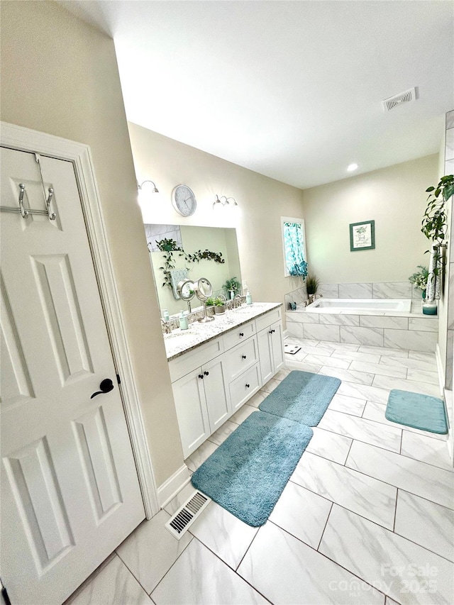5817 Wingate Hill Rd, Denver, NC 28037 - bathroom featuring double vanity, a garden tub, and marble look tiles