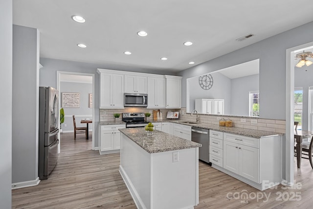 kitchen featuring visible vents, appliances with stainless steel finishes, decorative backsplash, and a sink