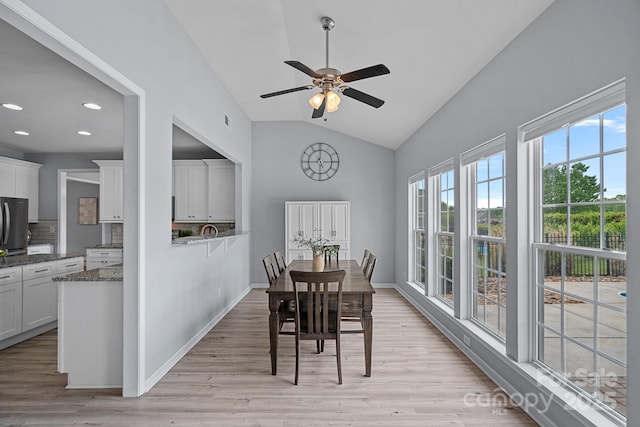 dining room featuring a ceiling fan, light wood finished floors, baseboards, lofted ceiling, and recessed lighting