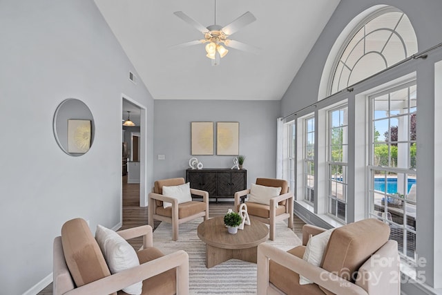 living room featuring baseboards, visible vents, wood finished floors, ceiling fan, and high vaulted ceiling