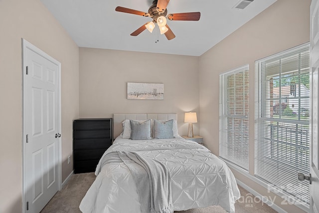 carpeted bedroom featuring visible vents, baseboards, and ceiling fan