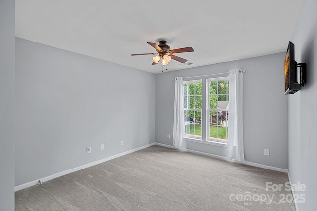 carpeted empty room featuring visible vents, baseboards, and ceiling fan