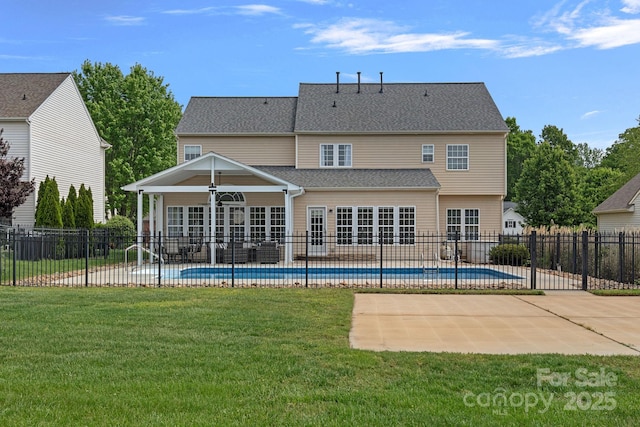rear view of property with a patio area, a lawn, and a fenced in pool