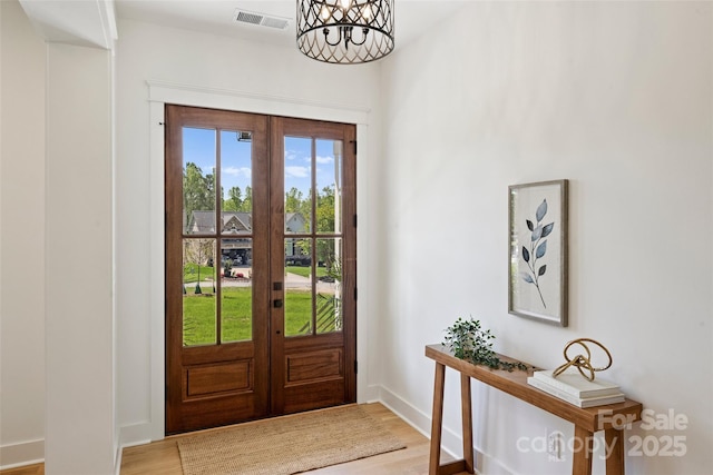 entryway with visible vents, wood finished floors, french doors, and baseboards