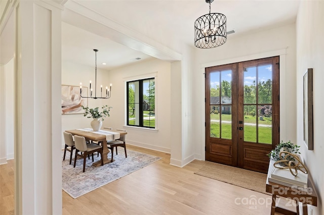 foyer entrance featuring visible vents, baseboards, an inviting chandelier, light wood finished floors, and french doors