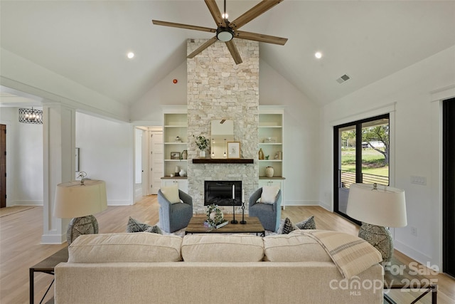 living room with ceiling fan, light wood-type flooring, high vaulted ceiling, and visible vents