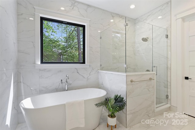 full bath featuring tile walls, a marble finish shower, a soaking tub, and marble finish floor