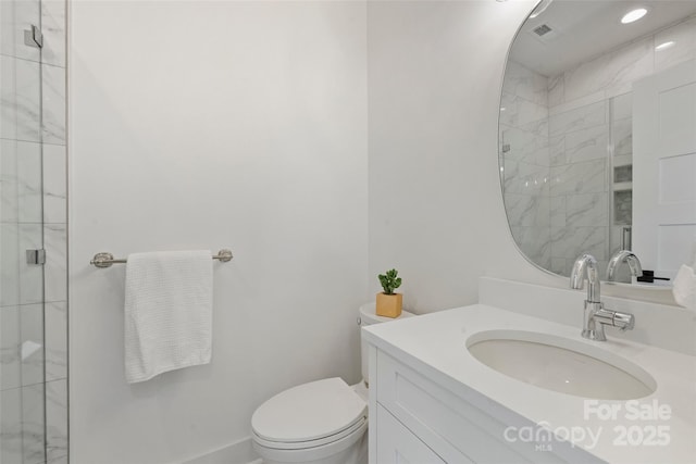 bathroom featuring visible vents, a shower stall, toilet, and vanity