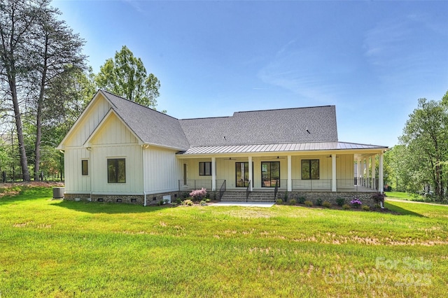 view of front of property with a front yard, crawl space, covered porch, board and batten siding, and roof with shingles