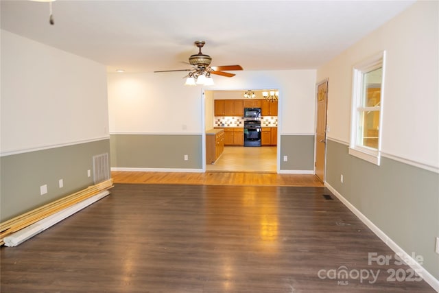 unfurnished living room with baseboards, visible vents, ceiling fan with notable chandelier, and light wood-style flooring