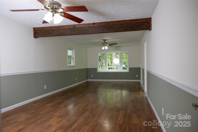 empty room with a ceiling fan, beam ceiling, wood finished floors, and baseboards