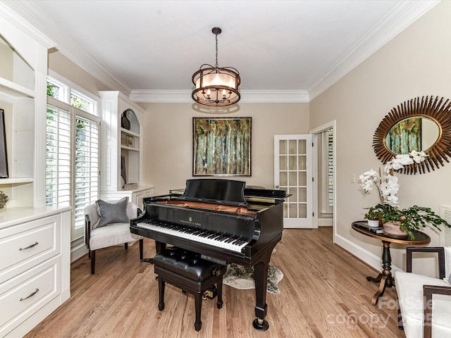 sitting room featuring crown molding, light wood finished floors, baseboards, and an inviting chandelier