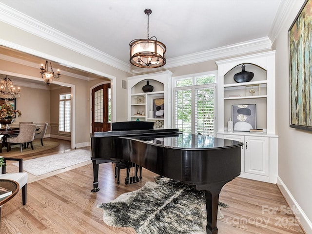 living area featuring a notable chandelier, built in shelves, baseboards, light wood-type flooring, and ornamental molding