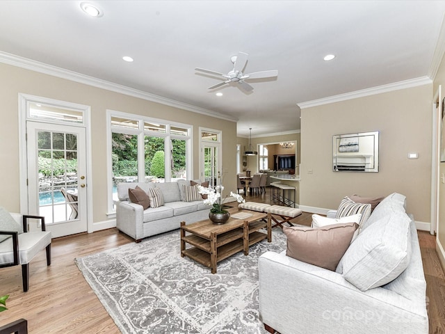 living room featuring recessed lighting, ornamental molding, light wood-style flooring, and ceiling fan