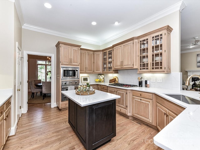 kitchen with crown molding, appliances with stainless steel finishes, a sink, light wood-style floors, and tasteful backsplash