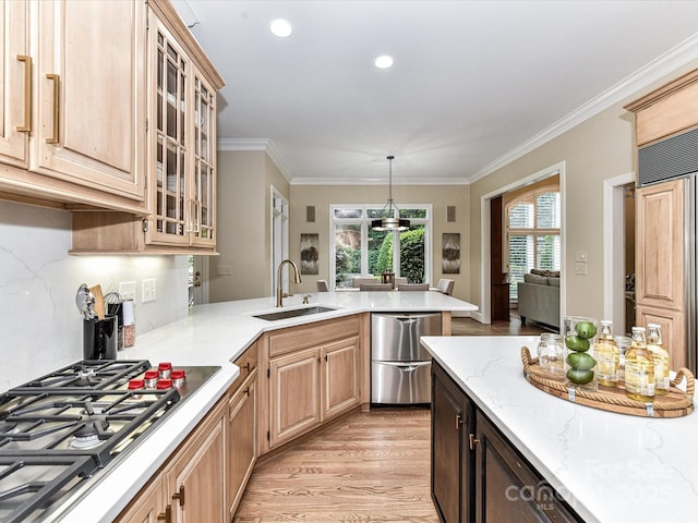 kitchen with stainless steel gas stovetop, light brown cabinets, light wood finished floors, and a sink