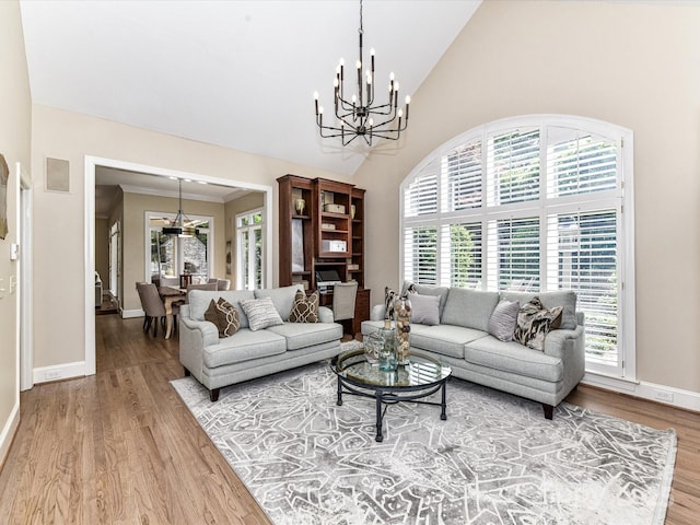 living room featuring wood finished floors, a notable chandelier, and a healthy amount of sunlight