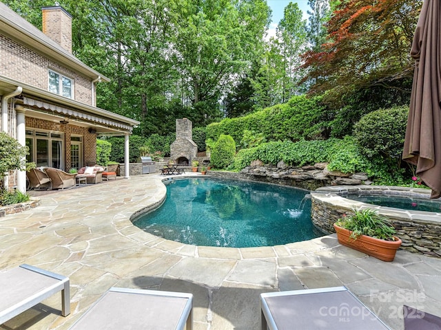 pool featuring an outdoor stone fireplace, a patio, and a grill