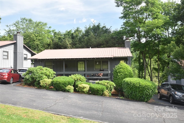 134 Raven Rdg, Maggie Valley, NC 28751 - view of front of property featuring board and batten siding, metal roof, and a chimney