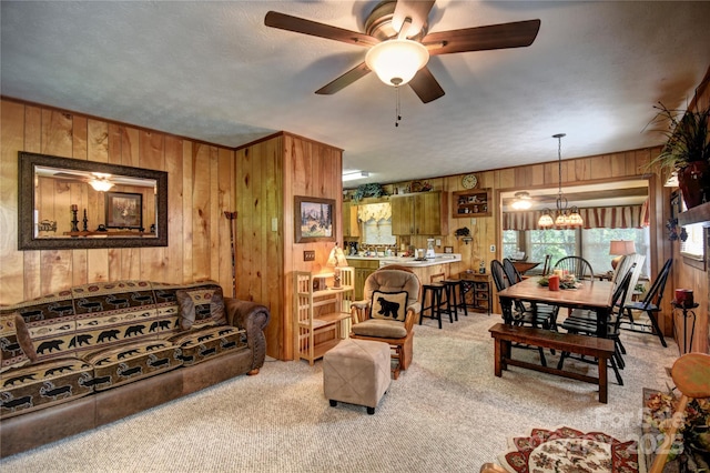 134 Raven Rdg, Maggie Valley, NC 28751 - living room with wood walls, carpet, a chandelier, and ceiling fan