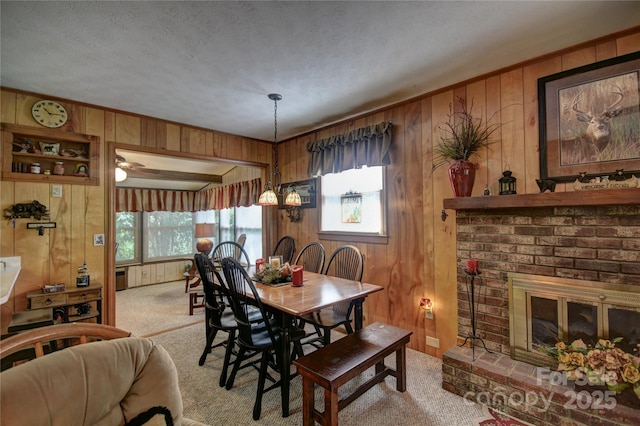 134 Raven Rdg, Maggie Valley, NC 28751 - carpeted dining area featuring wooden walls, plenty of natural light, a fireplace, and a textured ceiling