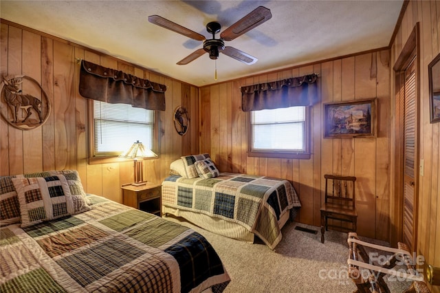 134 Raven Rdg, Maggie Valley, NC 28751 - bedroom with multiple windows, carpet floors, wooden walls, and ceiling fan