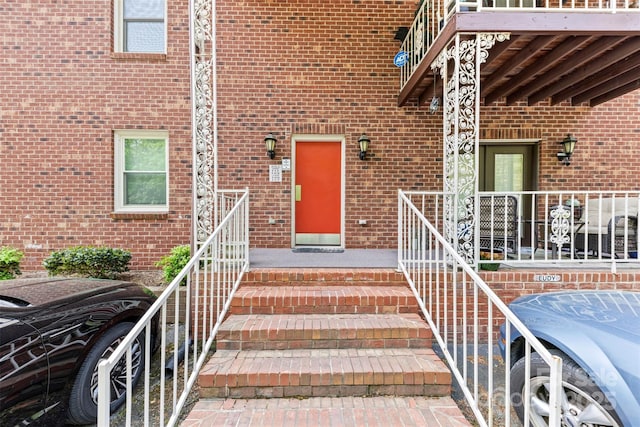 view of exterior entry featuring brick siding