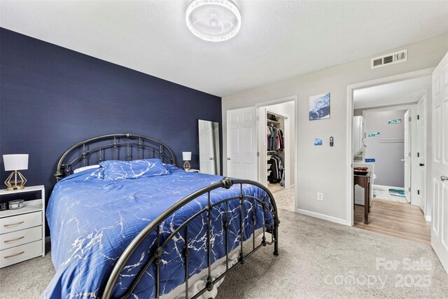 123 Carriage House Dr, Kannapolis, NC 28081 - bedroom with carpet floors, a walk in closet, baseboards, and a textured ceiling