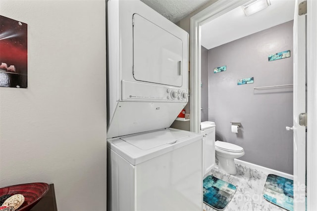 123 Carriage House Dr, Kannapolis, NC 28081 - bathroom featuring stacked washer and clothes dryer, toilet, baseboards, and marble look tiles