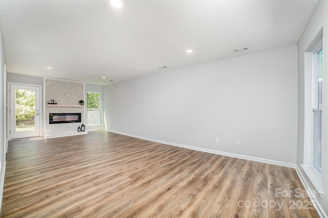 unfurnished living room with recessed lighting, baseboards, visible vents, and wood finished floors