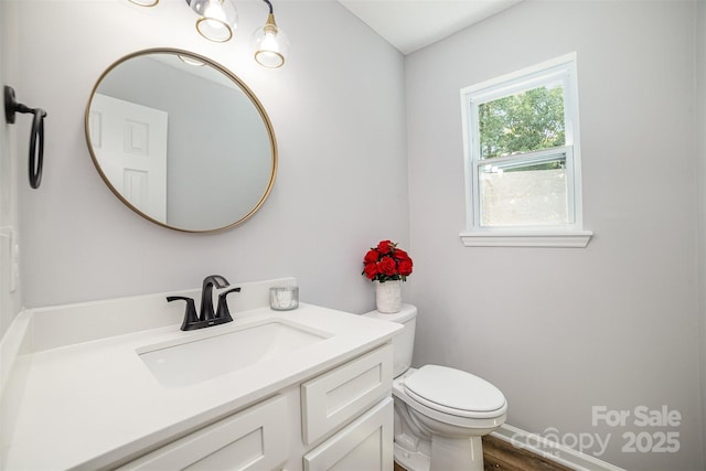bathroom with vanity, toilet, and wood finished floors
