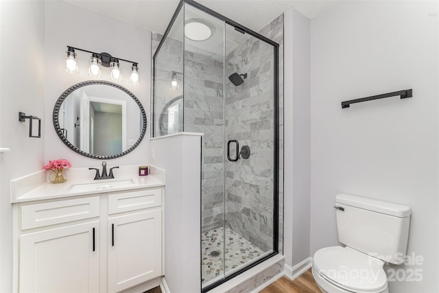 full bathroom featuring vanity, a stall shower, and toilet