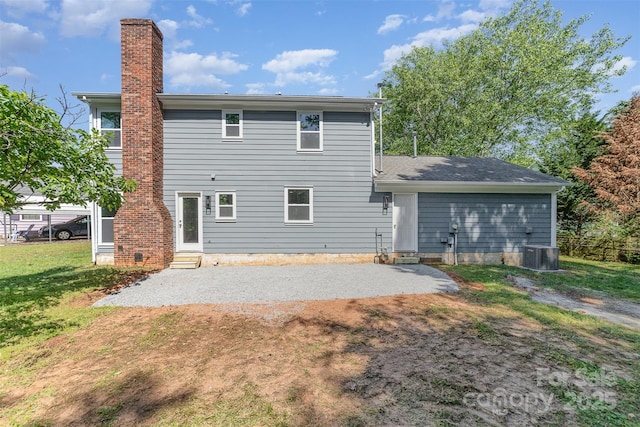 rear view of property featuring a lawn, a patio area, a chimney, and entry steps